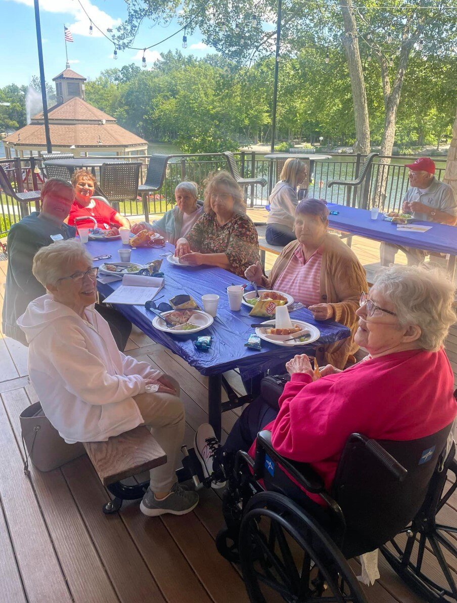 a group of people at a picnic table eating lunch